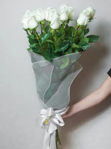Bouquet of white meter roses in a net