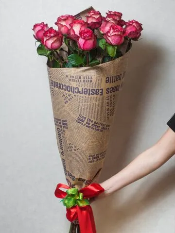 Bouquet of burgundy meter roses in kraft